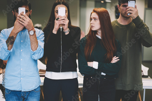 Young attractive hipster girl feeling confused about her friends can't stop texting messages sharing multimedia files blogging sites updating software while being addicted to smartphone and internet