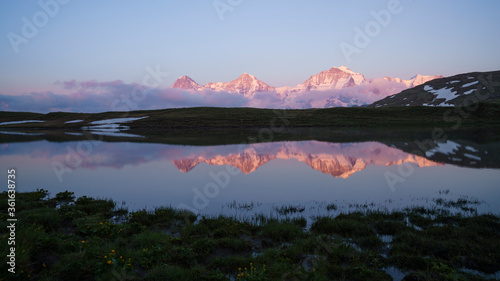 Eiger, Mönch und Jungfrau im Abendrot mit Spiegelung in Bergsee. Schweiz