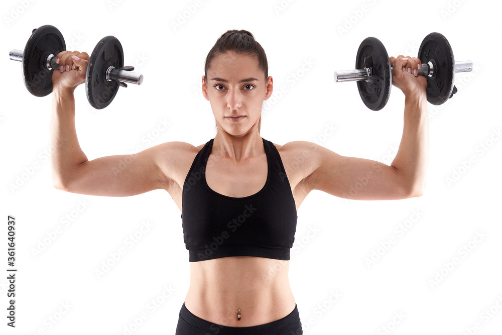 Obraz premium Young athletic woman working out with dumbbells