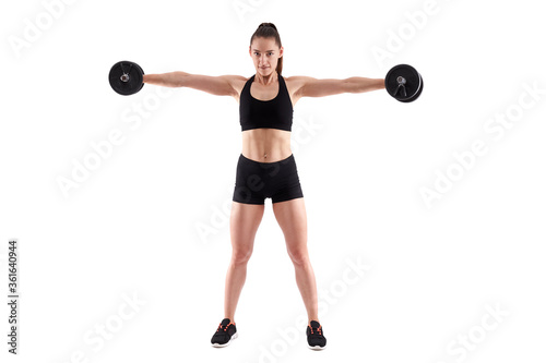 Young athletic woman working out with dumbbells