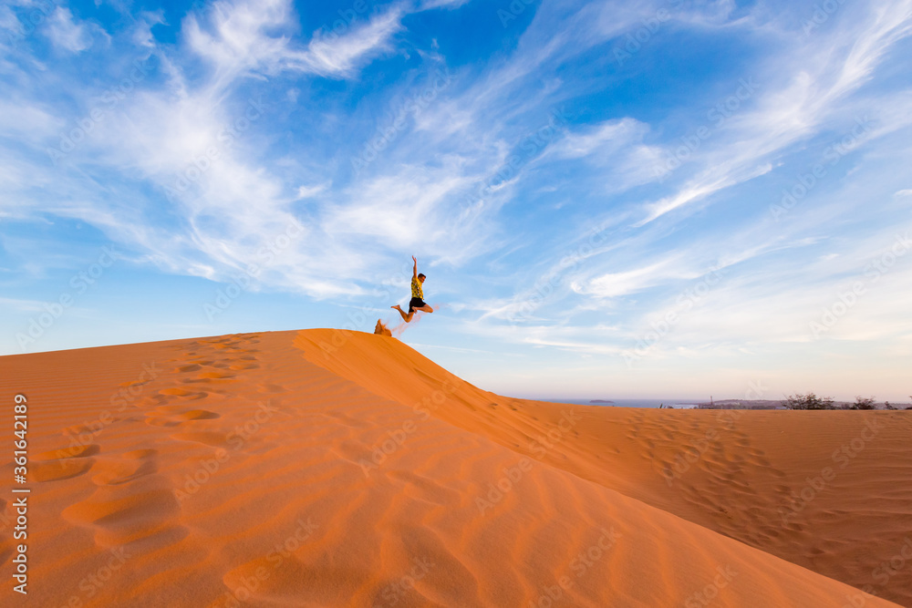 Young man on Red sand dunes in Vietnam