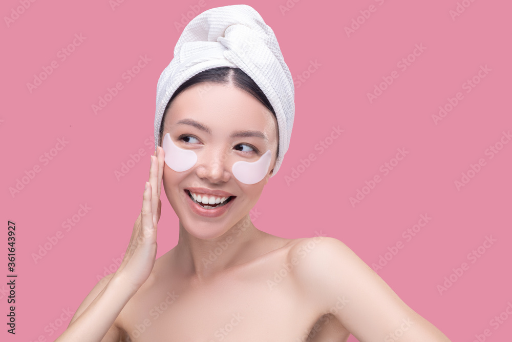 Smiling woman using new anti-ageing eye patches