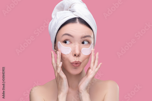 Woman using hyaluronic eye-patches for under eyes zone