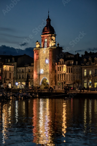 the grosse horloge of La Rochelle at night with beautiful illuminated city lights. portrait format