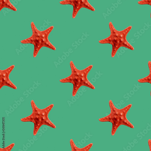 Red seastar seamless pattern isolated on green background