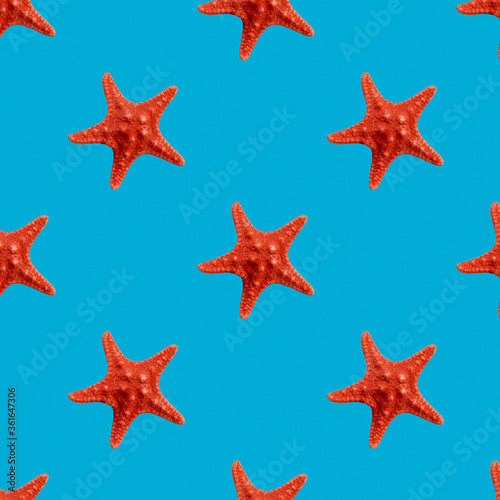 Red seastar seamless pattern isolated on blue background