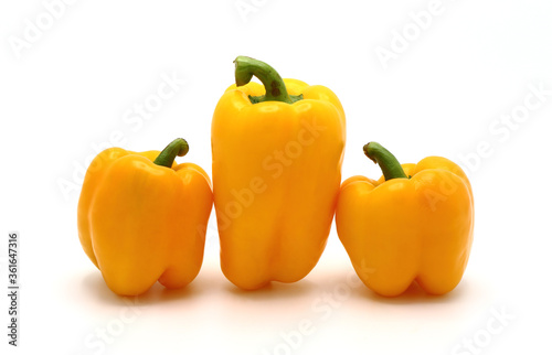 Three ripe sweet peppers of yellow color on a light background. Natural product. Natural color. Close-up.