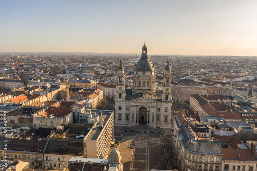 Aerial drone shot of St. Stephen's Basilica with empty square in Budapest sunrise glow