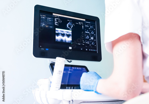 young woman doctor's hands close up preparing for an ultrasound device scan.