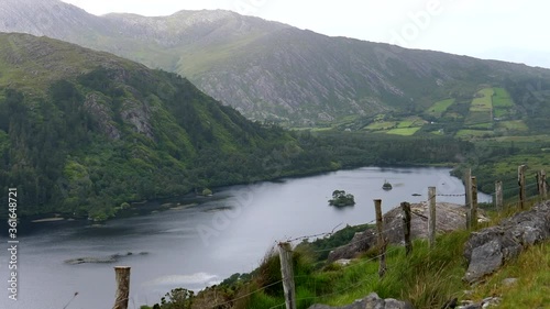 Car front passenger view of fantastic scenery of Glanmore lake and surrounding mountains while driving on steep edge of Irish highway R574 in County Kerry of Ireland. photo