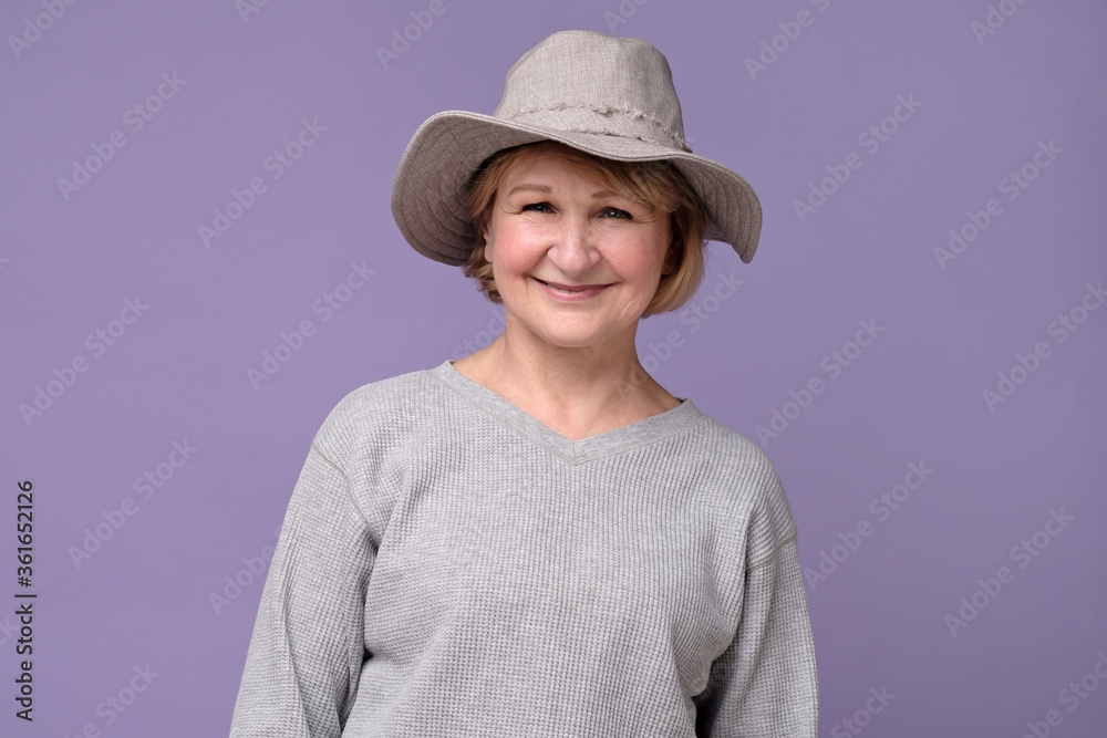 Smiling senior woman in summer hat laughing looking at camera. Grandmother feeling content smiling. Smiling senior woman in summer hat laughing looking at camera. Grandmother feeling content smiling.
