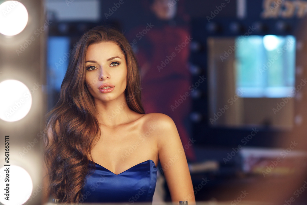 Young beautiful and pretty elegant lady in evening dress portrait. Stunning girl with long curly hair looking at you