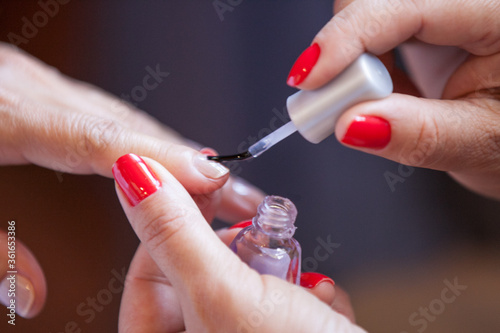 Manicure pintando as unhas de uma cliente photo