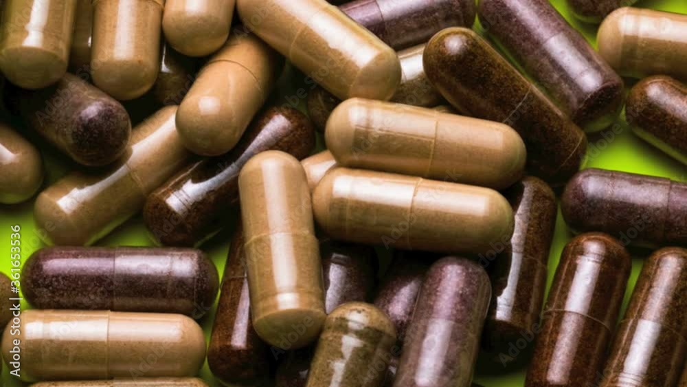 Close of various vitamin capsules spilled from a bottle Close of various vitamin capsules spilled from a bottle