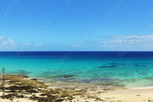 Tropical beach, azure ocean water and blue sky. Paradise landscape. Panorama