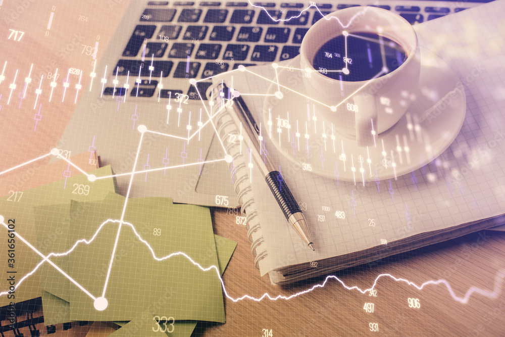 Double exposure of forex chart drawing and desktop with coffee and items on table background. Concept of financial market trading Double exposure of forex chart drawing and desktop with coffee and items on table background. Concept of financial market trading