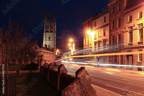 Fototapeta Naklejka Na Ścianę i Meble -  Streets of Oxford at night, floodlit tower with traffic trails in foreground