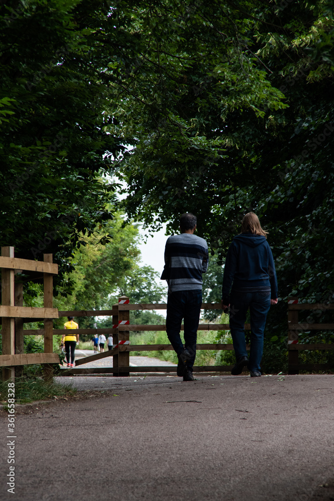 a back view of a middle-aged couple walking on a footpath