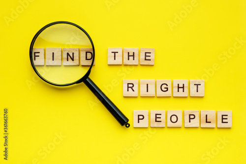 wooden block lettering find the right people and magnifying glass on yellow background. Human resource management, recruitment, hiring and employment creative concept. photo