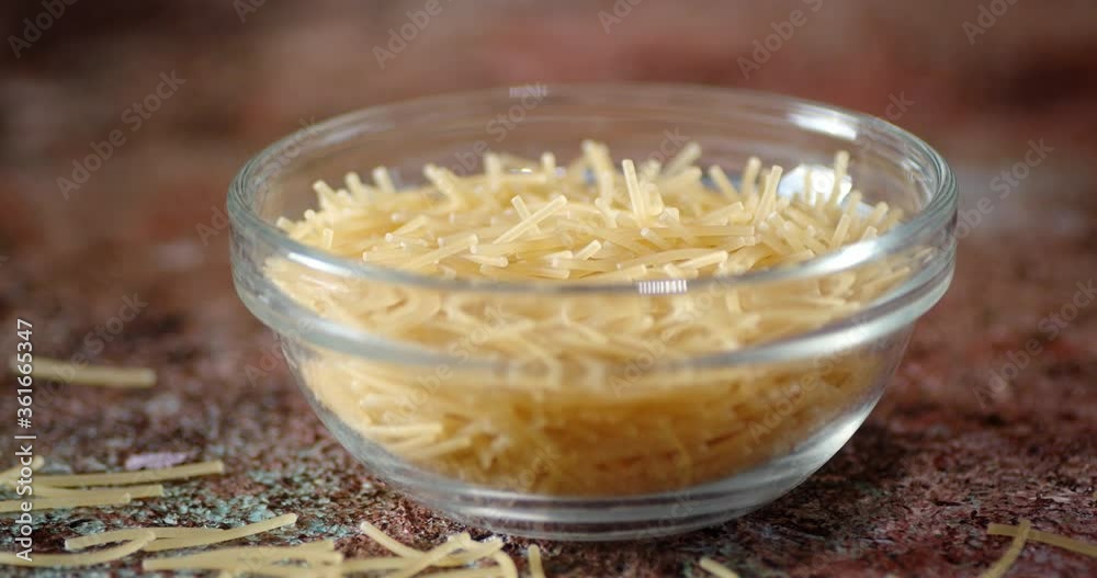 Dry pasta vermicelli in glass bowl slowly rotating. Dry pasta vermicelli in glass bowl slowly rotating.