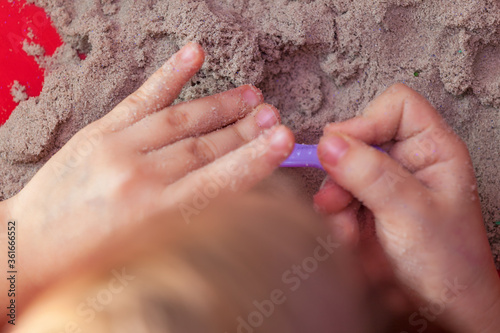 little hands playing with kinetic sand