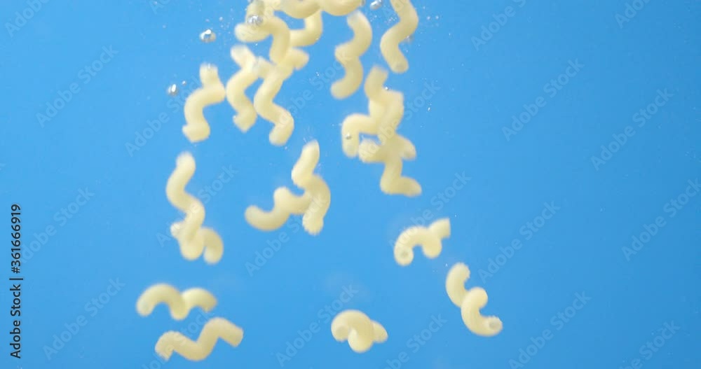 Pasta dry cavatappi falls under water with air bubbles. Pasta dry cavatappi falls under water with air bubbles.