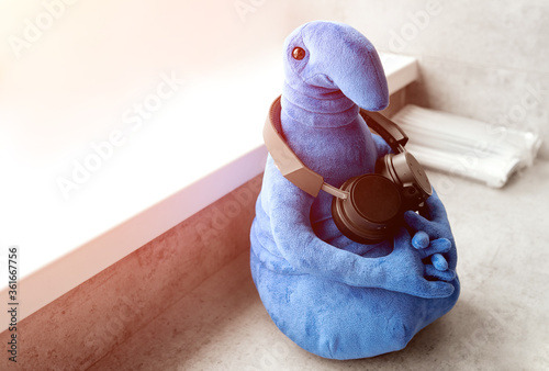 blue soft toy waiting jdun in black headphones on the windowsill  photo