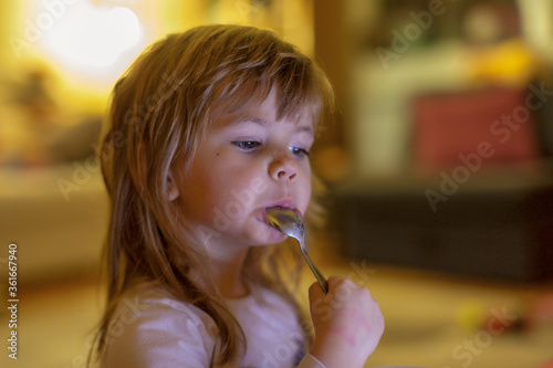 Obraz na płótnie little girl eats alone w salonie