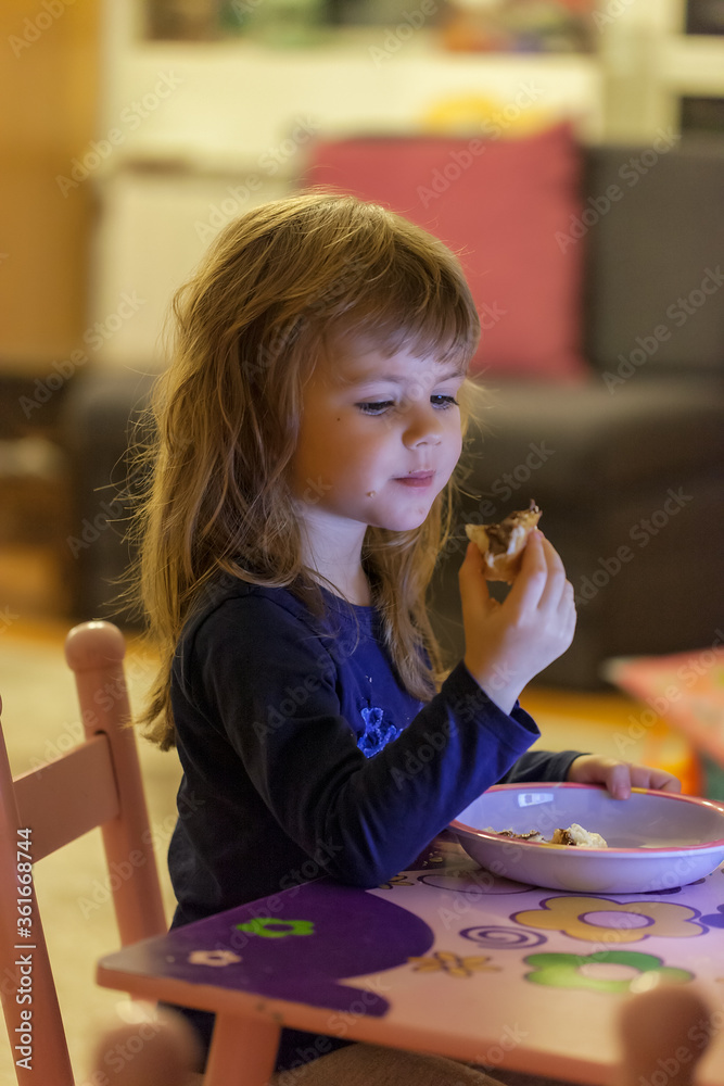 a little girl eating a donut