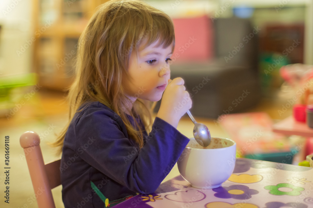 little girl eats alone