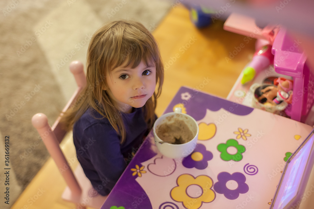 little girl eats alone