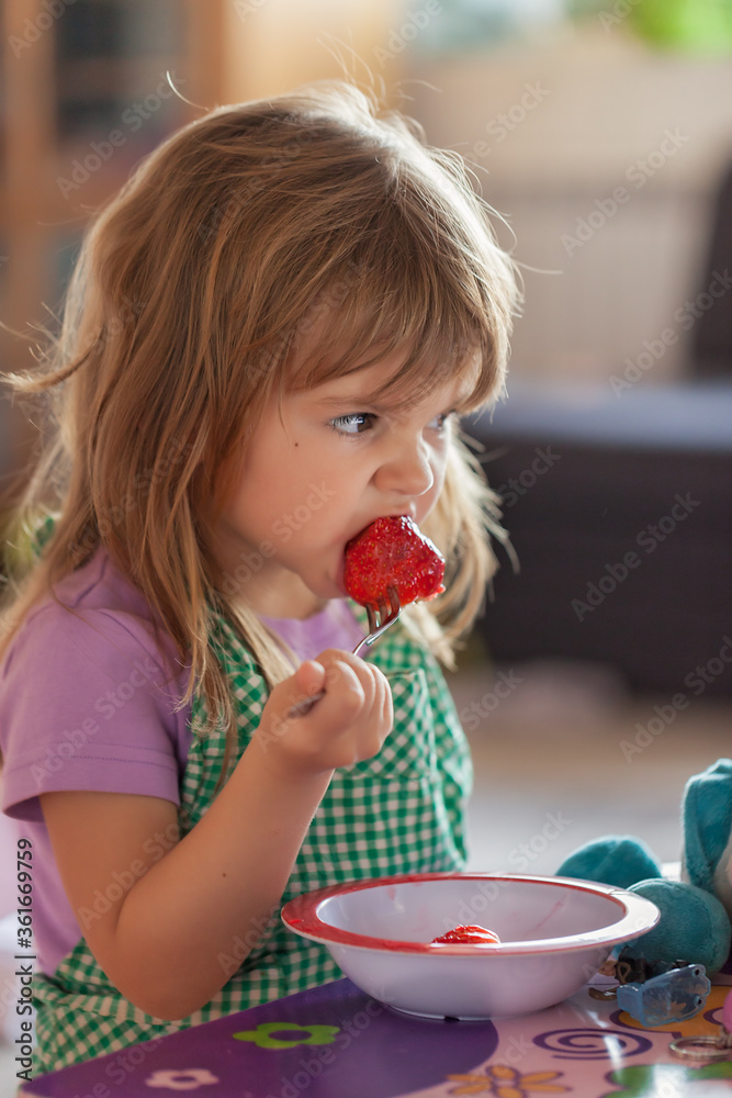 child eating strawberries