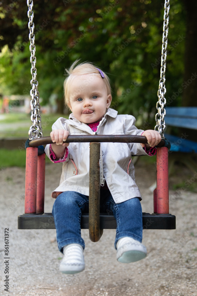A Young Toddler Girl Swinging in a Park A Young Toddler Girl Swinging in a Park