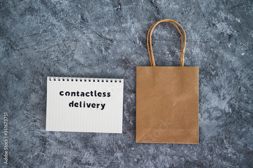 Contactless Delivery text on notepad with shopping bag concept of purchases during isolation and lockdown