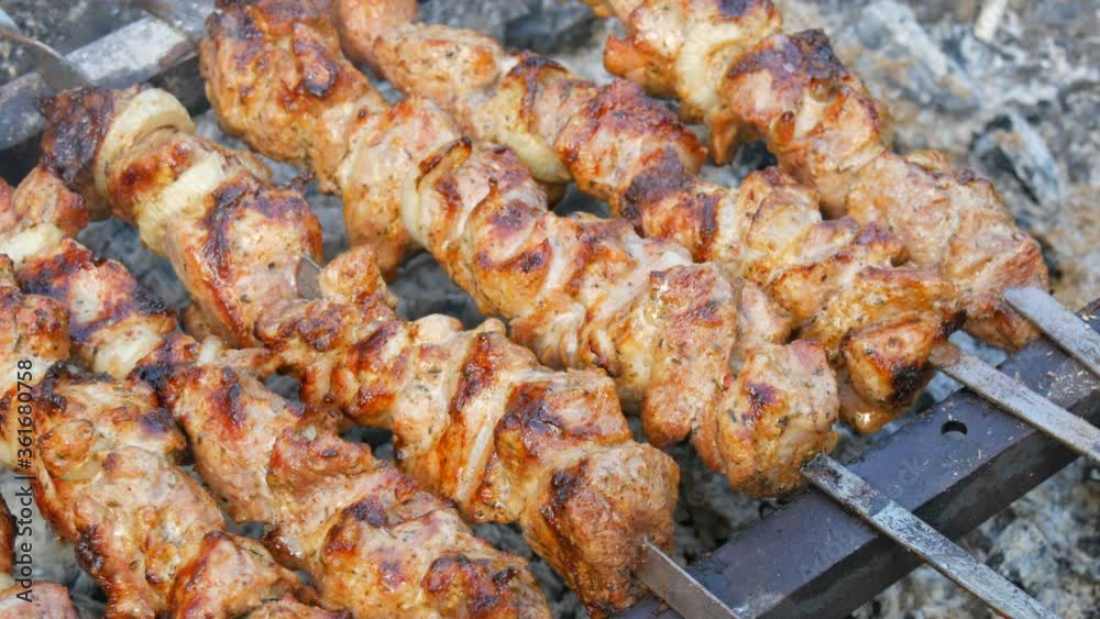 Sliced pieces of meat on a skewer. Pork skewers on the grill. Sliced meat with melting fat close up view in the garden of a country house
