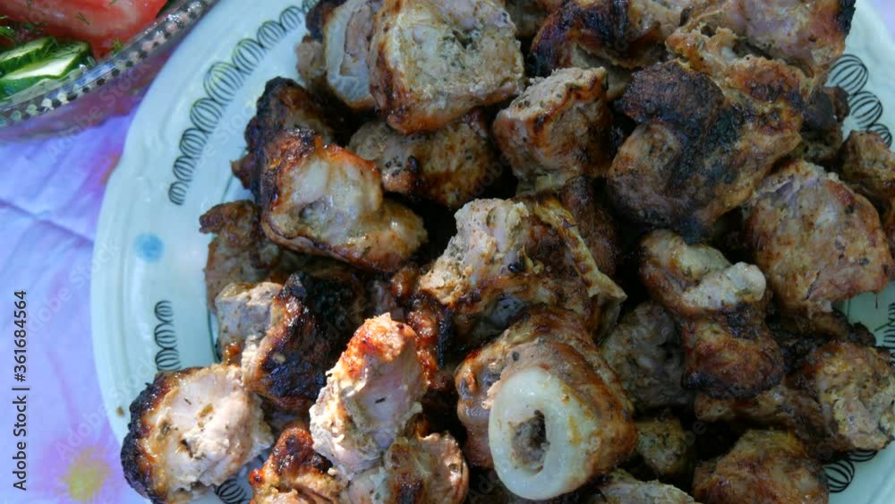Grilled pork slices in a large plate on a picnic in the garden. Grilled pork slices in a large plate on a picnic in the garden.