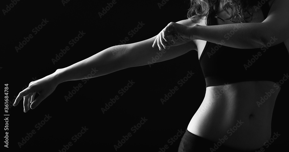 Naklejka premium Dancing woman silhouette. Choreography class. Graceful lady with bare belly performing movements isolated on black.