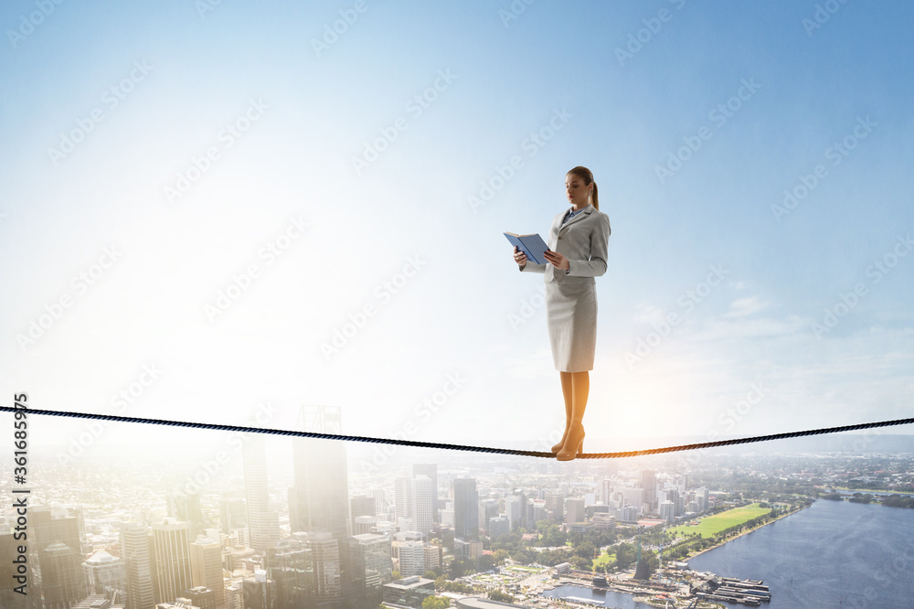 Woman on balancing rope with a book