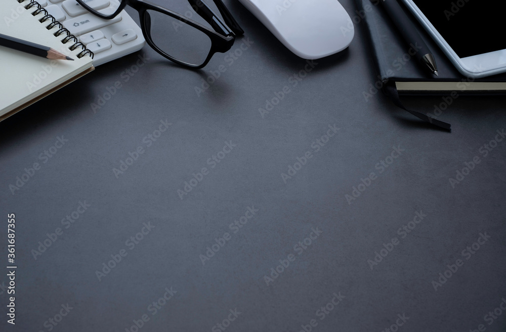 Dark grey office desk table with keyboard, notebook and glasses, mouse with equipment other office supplies. Business and finance concept. Workplace, Flat lay with blank copy space, top view. Dark grey office desk table with keyboard, notebook and glasses, mouse with equipment other office supplies. Business and finance concept. Workplace, Flat lay with blank copy space, top view.