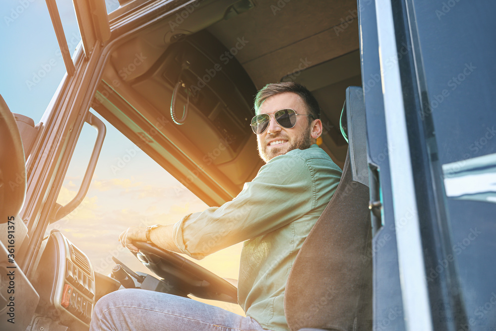 Naklejka premium Young driver in cabin of big truck