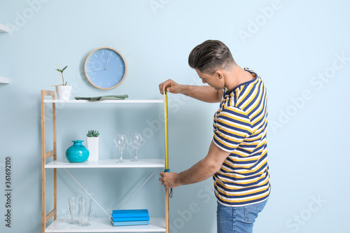 Young man taking measures o...