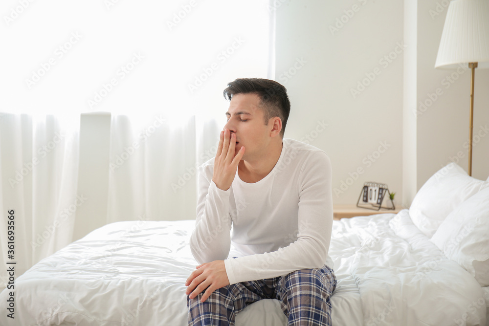 Young man suffering from sleep deprivation in bedroom Young man suffering from sleep deprivation in bedroom