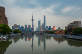 Sunset view of Waibaidu Bridge and Lujiazui, the skyline and landmark in Shanghai, China, with reflection in front.