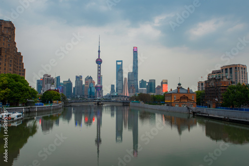 Sunset view of Waibaidu Bridge and Lujiazui, the skyline and landmark in Shanghai, China, with reflection in front.