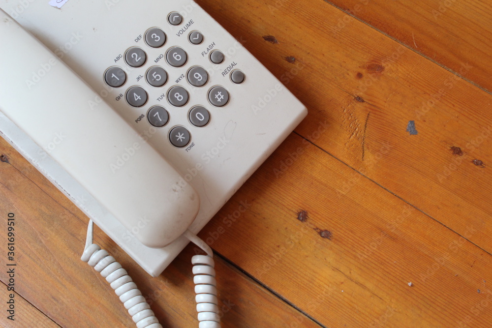 White telephone on wooden table with copy space