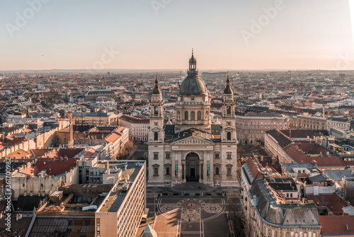 Aerial drone shot of St. Stephen's Basilica with empty square in Budapest sunrise glow © Davidzfr