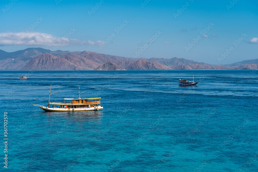 Crystal clear water and tourist boats around Flores island national park in summer season, Indonesia