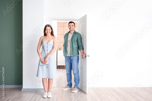 Happy couple near door at t...