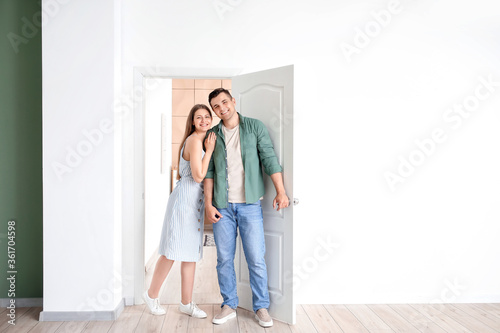 Happy couple standing in do...
