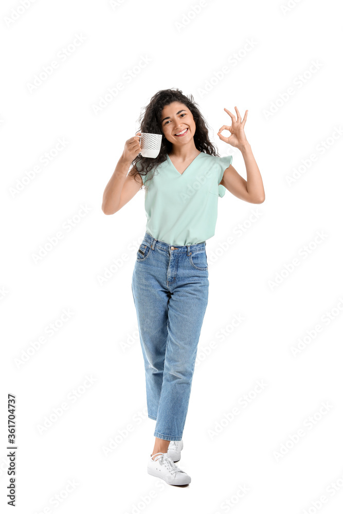 Beautiful young woman with hot tea showing OK on white background Beautiful young woman with hot tea showing OK on white background